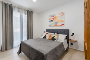 A bedroom with a bed, curtains, a nightstand, a lamp, and a wall art piece. - Room 'Camera 2 - P2' with Balcony, Wi-Fi, and Air Conditioning (Balestrate)