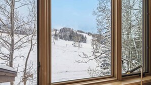 A room with a large window overlooking a snowy landscape. - Highlands Slopeside 222 (Beaver Creek)