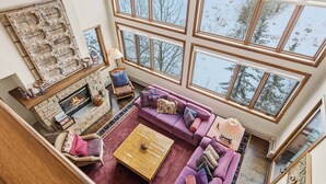 A spacious living room with a fireplace, large windows, and a cozy seating area. - Highlands Slopeside 502 (Beaver Creek)