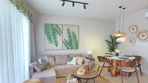 Ein modernes Wohnzimmer mit einer Couch, einem Couchtisch und einem Esstisch.