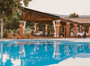 Un restaurante junto a la piscina con terraza.
