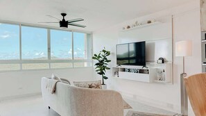 The living room features a cozy sofa, smart TV, ceiling fan and that jaw dropping view.  - BayCay Suite • Oceanfront w/ Mountain Views (Fajardo)