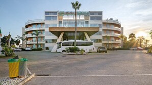 A modern hotel with a curved facade, multiple balconies, and a central entrance. - Apartment 'Paraíso do Atlântico' with Shared Pool, Garden, and Wi-Fi (Albufeira)