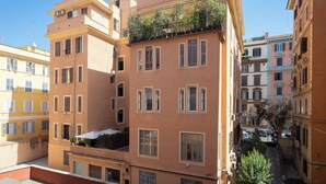 A multi-story building with balconies, windows, and a clear sky. - Rental in Rome Cesare Apartment (Rome)
