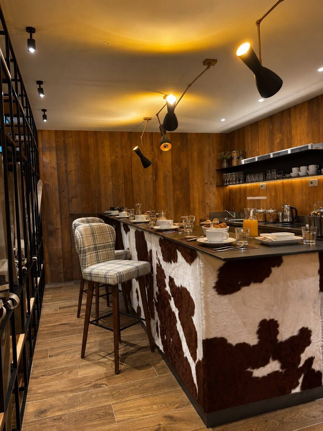 Una cucina moderna con isola centrale, sgabelli da bar e luci a sospensione.