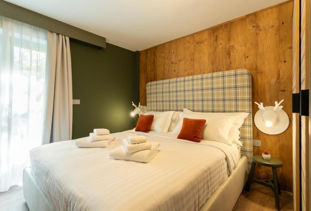 Ein Hotelzimmer mit einem großen Bett, einem Holzkopfstück und einem kleinen Nachttisch mit einer Lampe.