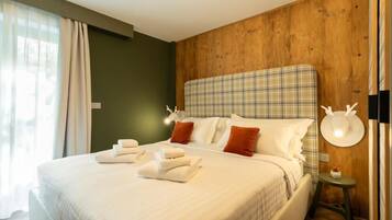 Ein Hotelzimmer mit einem großen Bett, einem Holzkopfstück und einem kleinen Nachttisch mit einer Lampe.
