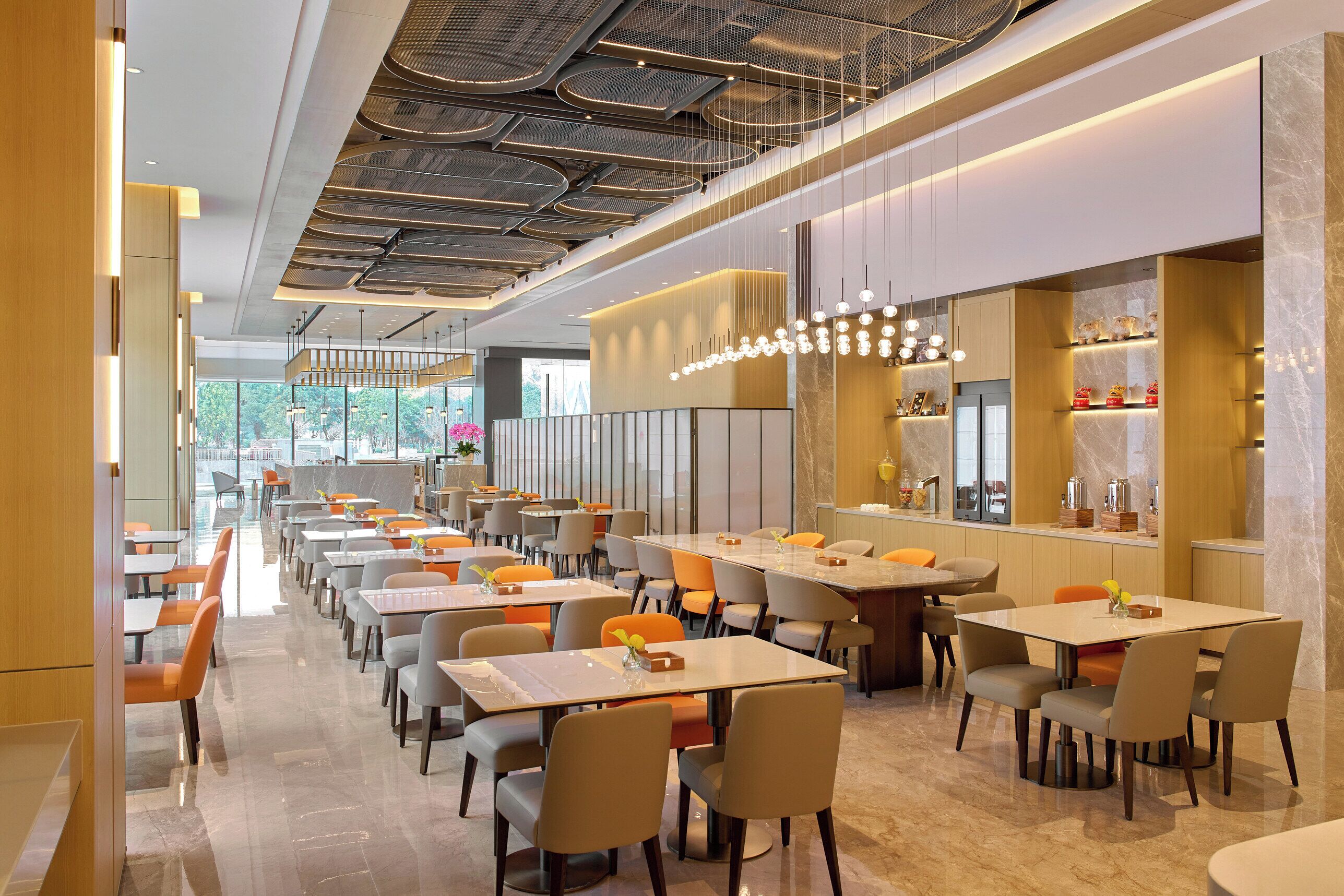 Un restaurante moderno con una barra alargada, varias mesas y sillas.