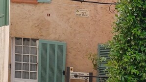 Un bâtiment avec un toit recouvert de tuiles, un lampadaire et une enseigne indiquant « Rue Saint-Esprit ».