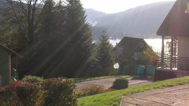 Una zona residencial con casas, cielo despejado y un lago al fondo.