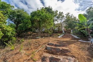 A garden pathway leading to a house with a white exterior and a red roof. - Ursula's Cozy Retreat in Santa Ursula (Santa Ursula)