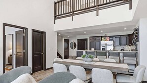Une cuisine moderne avec des meubles de couleur sombre, un îlot central et un lustre.