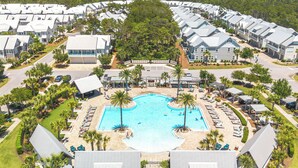 A resort with multiple white-roofed buildings, a central swimming pool, and surrounding palm trees. - Prominence Salt & Light - 6 Seat Golf Cart Included (Walton County)