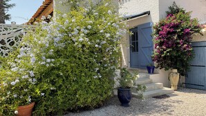 A house with a gravel driveway, a wooden fence, and potted plants. - LVAM – Villa Maraval · 8 Guests · 4 Bedrooms · Swimming Pool (Agde)