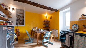 Een keuken met houten planken, een eettafel, stoelen en een raam.