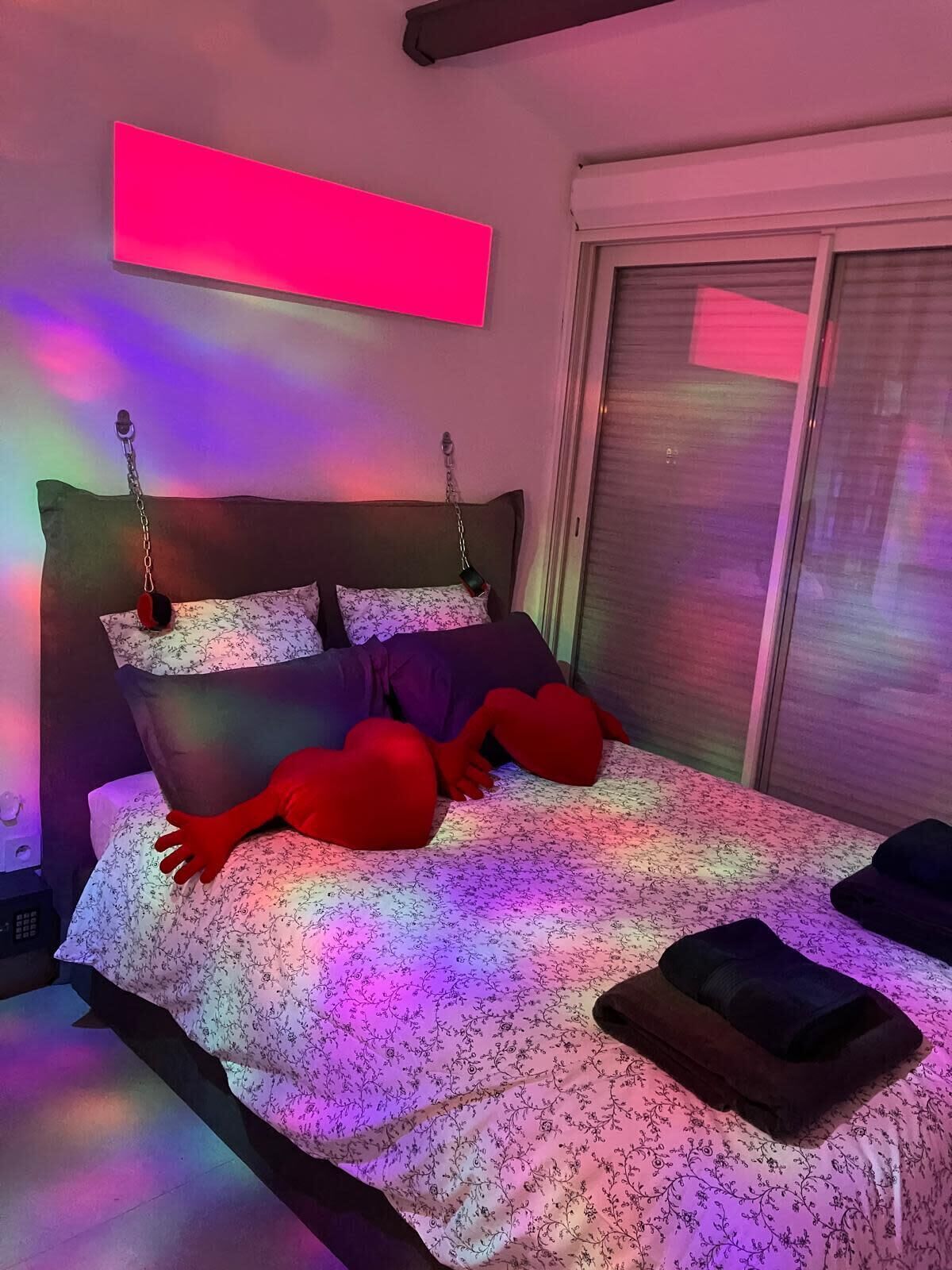 Een moderne slaapkamer met een bed, kussens en een hoofdeinde.