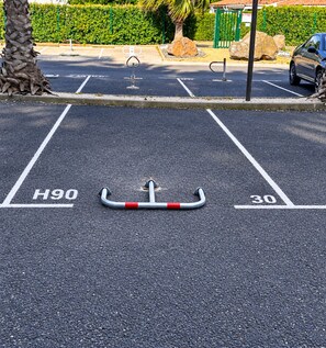 A parking area with marked spaces H90 and 30, a disabled parking space, and a palm tree. - Naturiste Cap d'Agde Héliopolis F 90 (Agde)