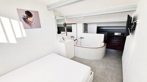 A modern bathroom with a bathtub, a sink, and a mirror. - Naturiste Cap d'Agde Villa Héliovillage 20 (Agde)