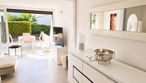 A modern kitchen with a large window, a dining area with chairs, and a white countertop. - Naturiste Cap d'Agde Villa Héliovillage 20 (Agde)