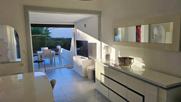 A modern kitchen with a dining area, a large window, and a view of the outdoors. - Naturiste Cap d'Agde Villa Héliovillage 20 (Agde)