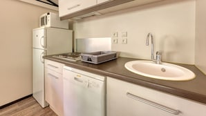 A compact kitchenette with a built-in microwave, a small refrigerator, a dishwasher, a sink, and a countertop with a toaster. - Lou Pitchoun - Cottage pour 5 (Solliès-Toucas)