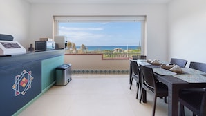 A balcony with a dining table and chairs, a microwave, and a trash bin. - Room '4' with Sea View, Wi-Fi and Air Conditioning (Balestrate)