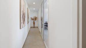 A hallway with framed artwork on the walls, a potted plant, and a dining area visible through a glass partition. - Room '4' with Sea View, Wi-Fi and Air Conditioning (Balestrate)