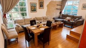 A spacious living area with a dining table, sofas, and a staircase. - VillaBerria, 9Host, Pool, BBQ, Jcuzzi, Oasis Palma (Marratxí)