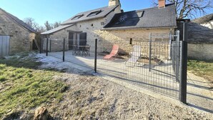 A stone building with a fenced patio area, outdoor seating, and a chimney. - Cozy house for couple with private spa in Périgord (Les Coteaux Périgourdins)