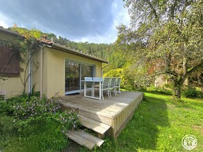 Ein Haus mit einer Terrasse, einer Schiebetür und einem Garten.