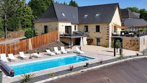 A stone house with a swimming pool, outdoor seating, and a wooden deck. - Large Family House with Private Pool and Pets Welcome (Coubjours)