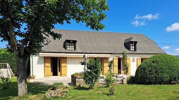 A two-story house with a sloped roof, a small porch, and a well-maintained lawn. - Comfortable Country House in Dordogne (Saint-Rabier)