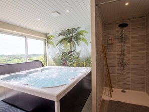 A modern bathroom with a jacuzzi, a shower, and a large window offering a view of the countryside. - Cottage for 11 with parking, spa, pets allowed (Paulin)