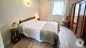 A bedroom with a bed, bedside lamps, a window with curtains, a chair, and a wardrobe. - Cottage for 11 with parking, spa, pets allowed (Paulin)