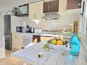 A modern kitchen with white cabinets, a stainless steel refrigerator, a microwave, a toaster, and a sink. - Modern duplex loft with terrace in Torremolinos (Torremolinos)