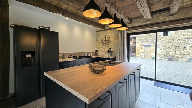 A modern kitchen with a central island, dark cabinetry, and pendant lighting. - Stone house in Périgord, sleeps 10, authentic charm (La Chapelle-Aubareil)