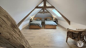 A bedroom with two beds, wooden beams, and a skylight. - Stone house in Périgord, sleeps 10, authentic charm (La Chapelle-Aubareil)