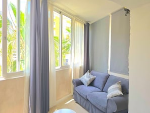 A living room with a grey sofa, two pillows, and a window with curtains. - Modern studio in central Torremolinos (Torremolinos)