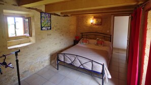 Una camera da letto con un letto, una finestra, una lampada a muro e una porta.