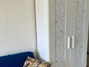 A room with a blue sofa, a patterned wallpaper, and a white wardrobe. - Modern Studio Benalmádena with Views (Marbella)