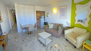 Un salon comprenant un canapé, une table basse et un coin repas avec des chaises et une table.
