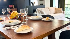 Een eettafel gedekt met borden, glazen en een schaal fruit.