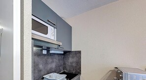 A kitchen with a microwave, oven, and a sink. - Studio in Lamalou-les-Bains near center with Wifi (Lamalou-les-Bains)
