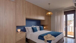 Une chambre moderne avec un grand lit, une armoire en bois, des lampes de chevet et une vue sur l’extérieur grâce à une porte vitrée.