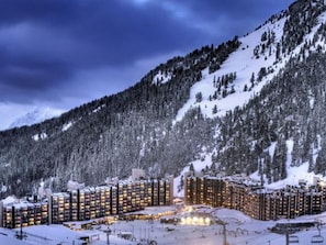 Ein schneebedecktes Resort mit mehreren Hochhäusern, Skipisten und einer Seilbahn.