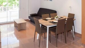 Et moderne spiseområde med et bord til fire personer, en sofa og en bænk.