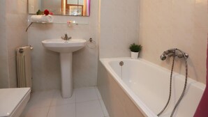 A bathroom with a white sink, a bathtub, and a mirror. - Cozy Studio with Terrace, Pools, AC, Near Beach, Sleeps 4 (Salou)