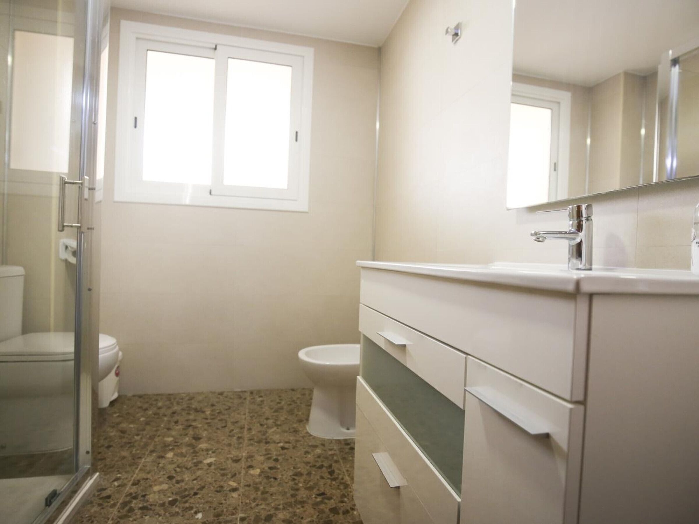 A bathroom with a shower, toilet, and vanity.