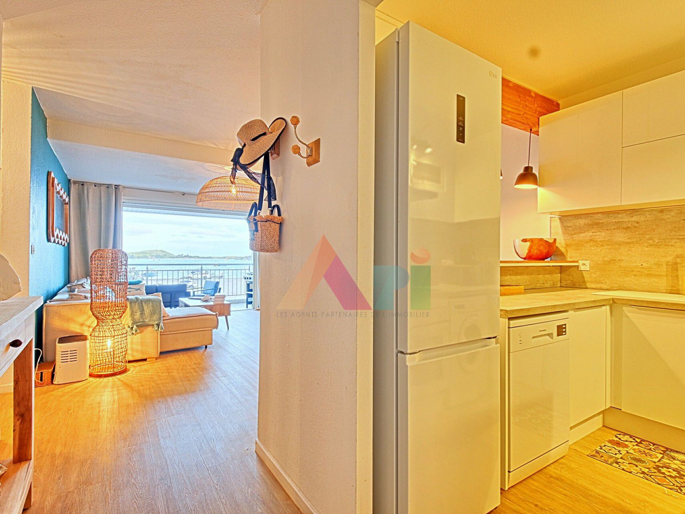 A modern apartment with a kitchen, dining area, and a balcony with a view.