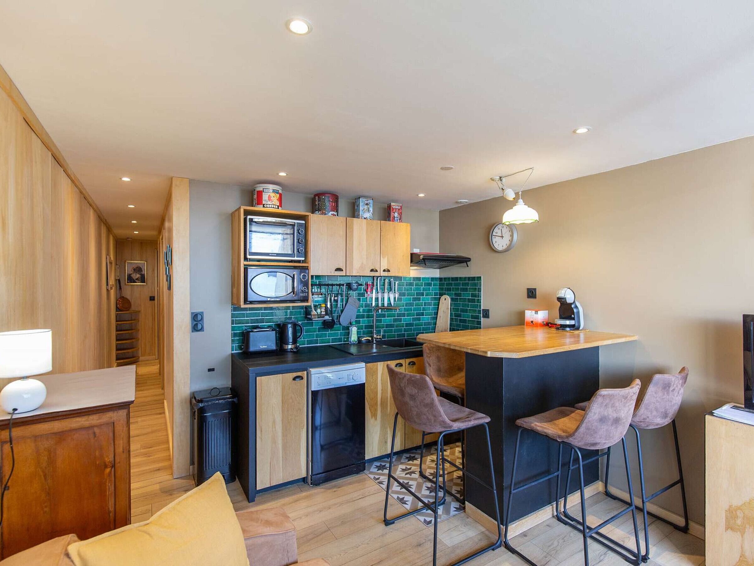 A compact kitchen with a central island, built-in appliances, and a small dining area with bar stools.